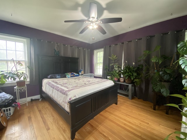 bedroom featuring ceiling fan, baseboards, and light wood-style floors