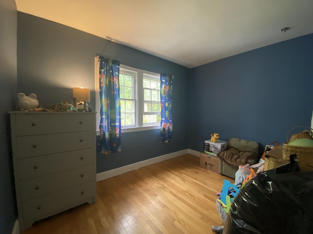 bedroom featuring light wood-style floors and baseboards