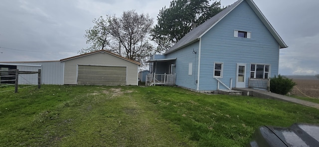 back of property featuring an outbuilding, a yard, and a garage