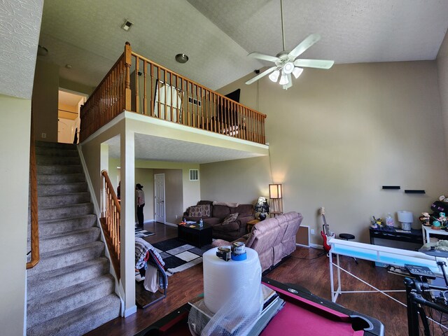 2380 W Patterson Ln, Troy, OH 45373 - living area featuring wood finished floors, ceiling fan, a towering ceiling, stairs, and a textured ceiling