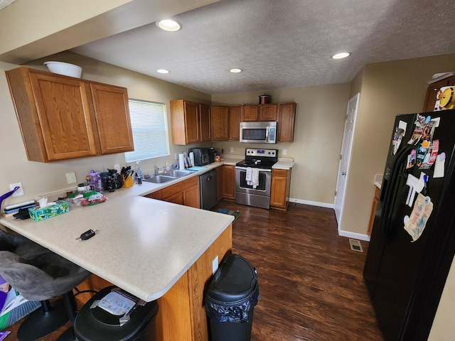2380 W Patterson Ln, Troy, OH 45373 - kitchen with appliances with stainless steel finishes, a peninsula, brown cabinets, light countertops, and recessed lighting