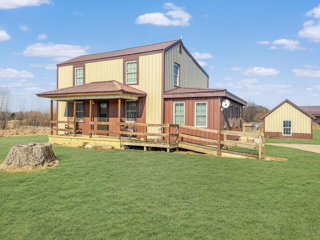 back of house featuring metal roof and a yard