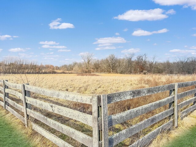 view of yard with a rural view and fence