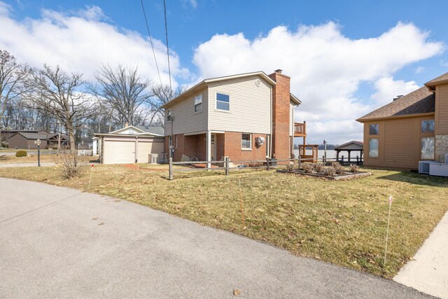 10989 Seminole Shore Dr, Huntsville, OH 43324 - view of side of property featuring brick siding, a chimney, an outbuilding, a detached garage, and central AC unit