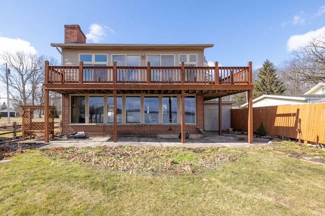 back of house with a deck, a patio, a fenced backyard, a lawn, and a chimney