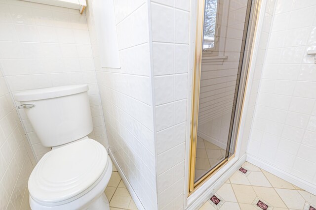 10989 Seminole Shore Dr, Huntsville, OH 43324 - bathroom featuring a shower stall, tile patterned flooring, tile walls, and toilet
