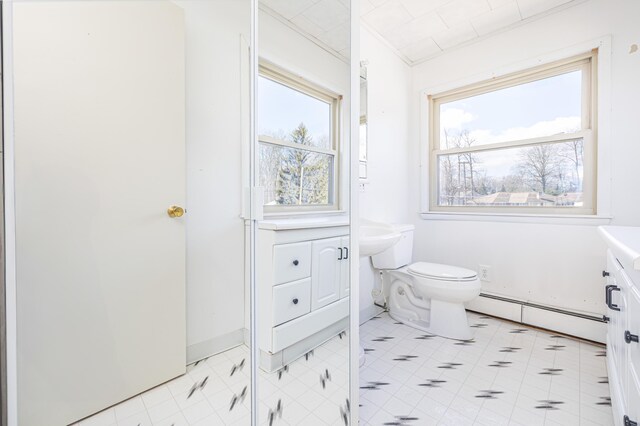 10989 Seminole Shore Dr, Huntsville, OH 43324 - bathroom with baseboard heating, healthy amount of natural light, toilet, and vanity