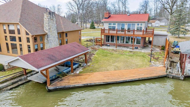 10989 Seminole Shore Dr, Huntsville, OH 43324 - rear view of property with a chimney, a lawn, a deck with water view, and a shingled roof