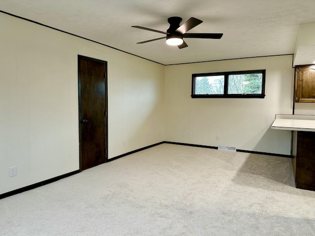 spare room featuring visible vents, ceiling fan, a textured ceiling, and carpet flooring