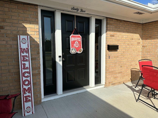 doorway to property with brick siding