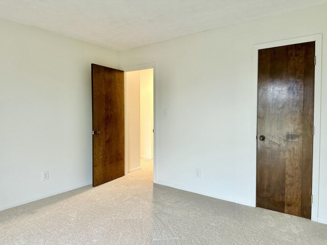 unfurnished bedroom featuring carpet flooring and baseboards