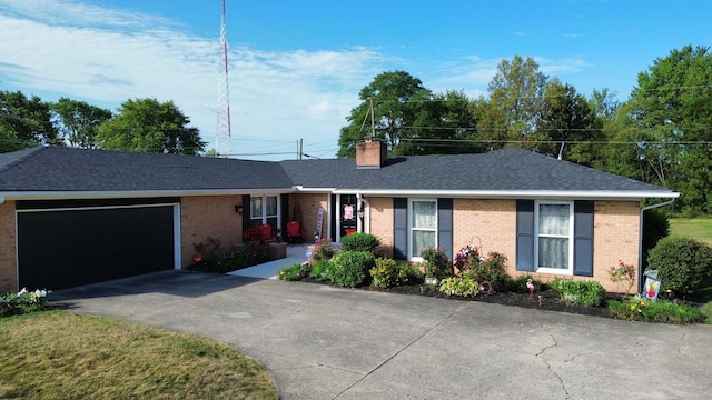 ranch-style home with brick siding, roof with shingles, a chimney, an attached garage, and driveway