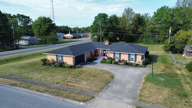 ranch-style house featuring an attached garage, driveway, brick siding, and a front yard