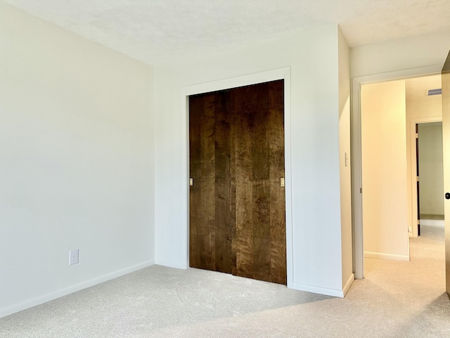 unfurnished bedroom featuring carpet, visible vents, and baseboards