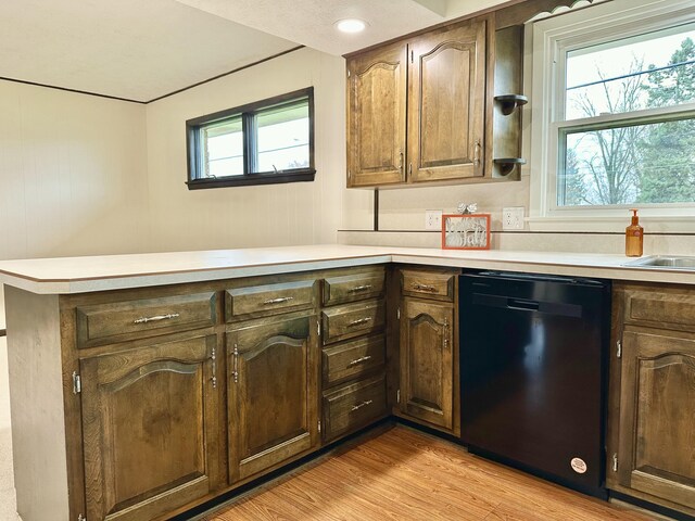 kitchen with black dishwasher, a peninsula, plenty of natural light, and light countertops