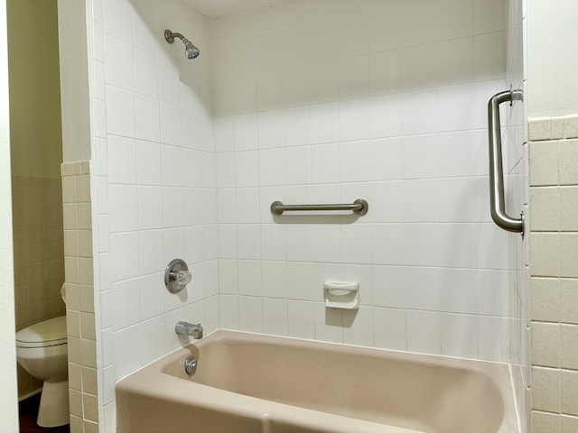 bathroom featuring toilet, wainscoting, and tile walls