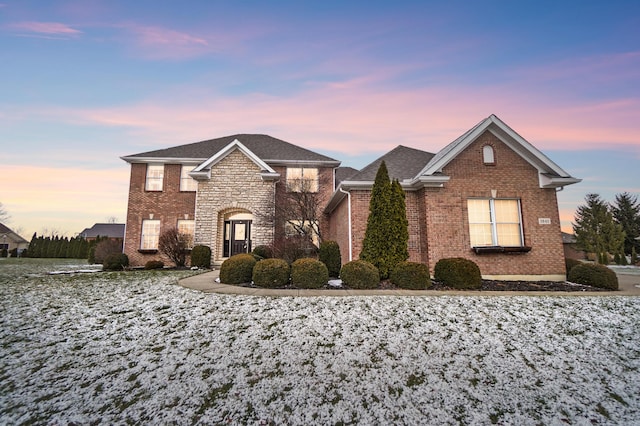 traditional home with stone siding and brick siding