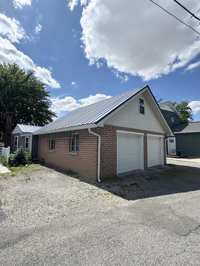 13864 Public Dr, Lakeview, OH 43331 - view of side of property featuring brick siding, metal roof, and a detached garage