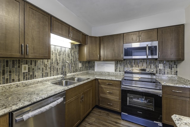 3112 Legend Way, Dayton, OH 45449 - kitchen featuring appliances with stainless steel finishes, backsplash, dark wood finished floors, light stone counters, and dark brown cabinets