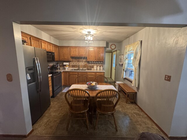 612 S Main St, Saint Marys, OH 45885 - kitchen featuring black appliances, brown cabinets, a sink, backsplash, and light countertops