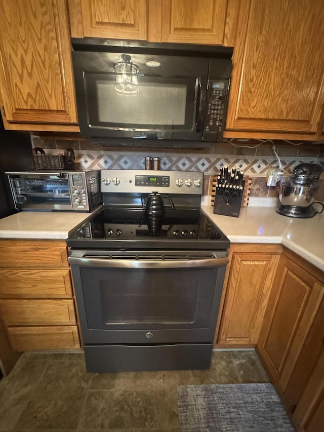 612 S Main St, Saint Marys, OH 45885 - kitchen featuring stainless steel range with electric cooktop, black microwave, light countertops, and backsplash
