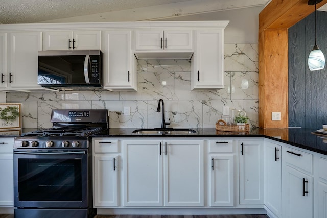 kitchen with white cabinetry, decorative backsplash, gas stove, and a sink