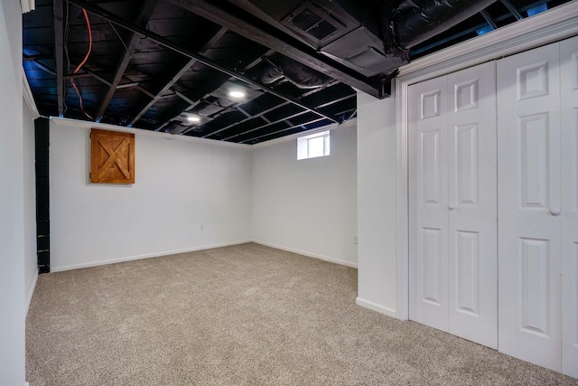 basement featuring visible vents, baseboards, and carpet floors