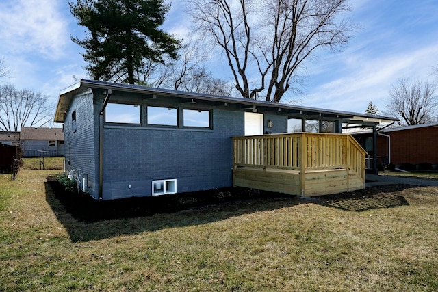 back of property with brick siding, a deck, and a yard