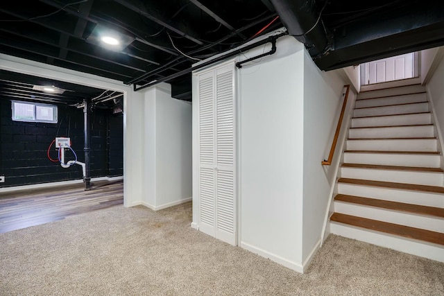 basement with baseboards, carpet floors, and stairs