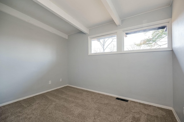 empty room featuring visible vents, vaulted ceiling with beams, carpet, and baseboards