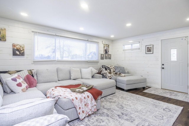 living room featuring dark hardwood / wood-style floors and wood walls