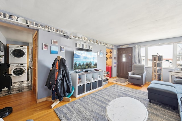 living area featuring stacked washer and clothes dryer and wood finished floors