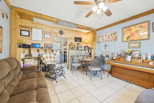 tiled living room with ceiling fan and wood walls