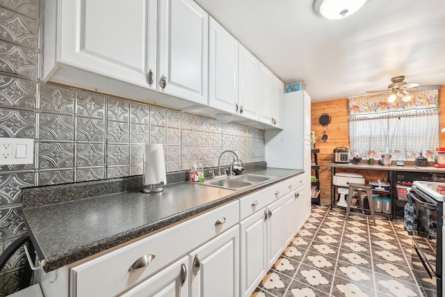 kitchen with black electric range, a sink, backsplash, white cabinets, and ceiling fan