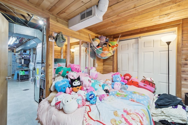 bedroom with wooden walls, wood ceiling, visible vents, and a closet