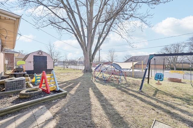 view of yard with an outbuilding, cooling unit, fence, playground community, and a storage shed