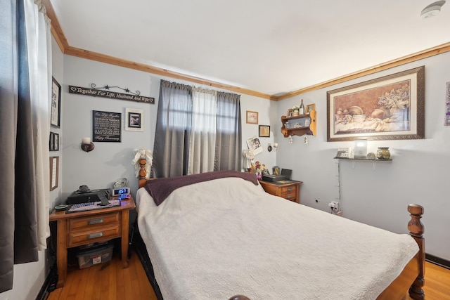 bedroom featuring ornamental molding and wood finished floors