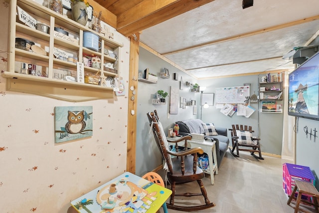 sitting room with tile patterned floors, baseboards, and beam ceiling