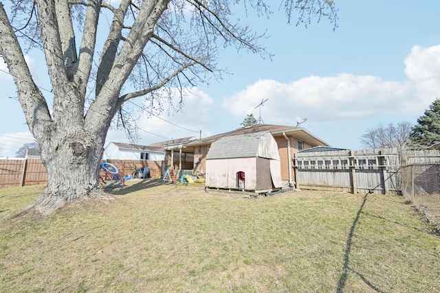 view of yard featuring a storage shed, an outbuilding, and a fenced backyard