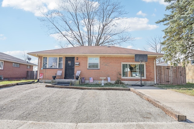 view of front of property featuring fence and brick siding