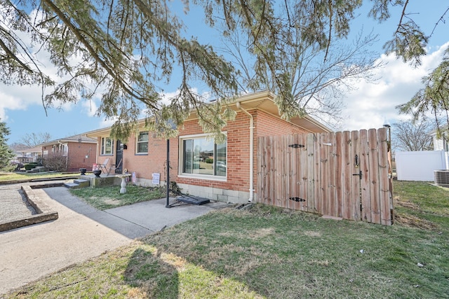 view of front of house with brick siding, a front yard, and fence