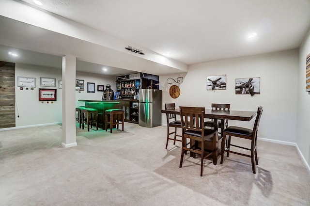 dining room with a dry bar, recessed lighting, baseboards, and light carpet