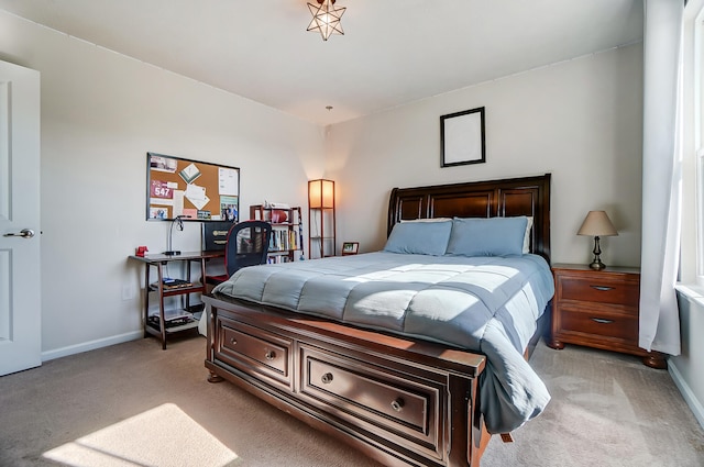 bedroom with baseboards and light colored carpet