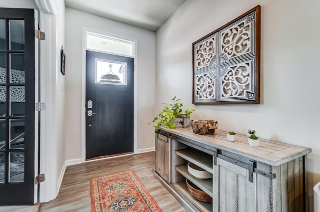 foyer entrance featuring light wood-style flooring and baseboards