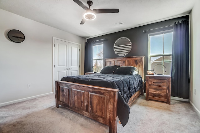 bedroom featuring light carpet, visible vents, multiple windows, and baseboards