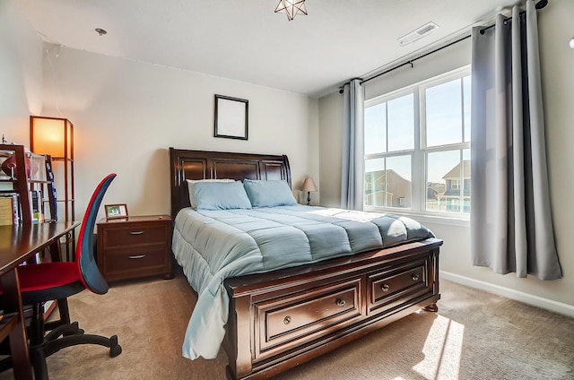 bedroom featuring visible vents, light carpet, and baseboards