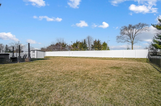 view of yard featuring an outdoor structure, a fenced backyard, and a shed