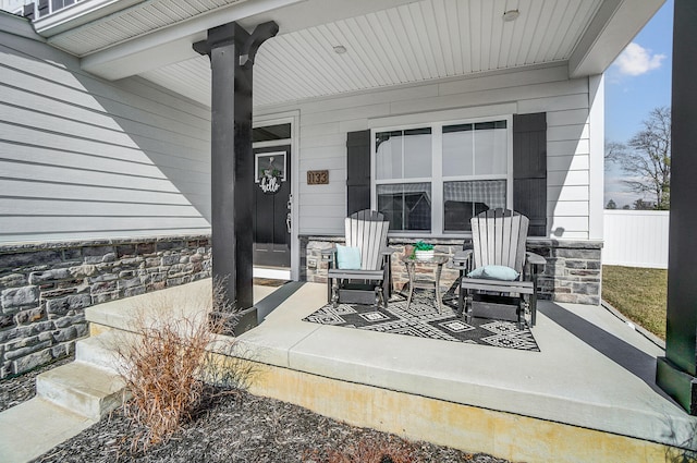 view of patio / terrace featuring a porch and fence