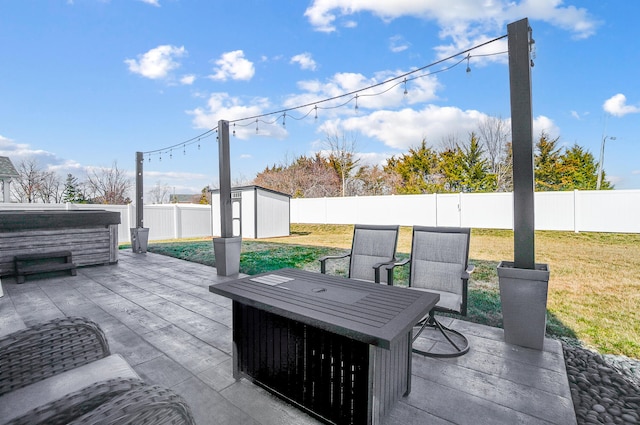 view of patio with an outdoor structure, a fenced backyard, a shed, and a hot tub