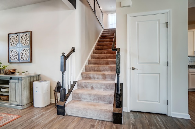 stairs with baseboards and wood finished floors